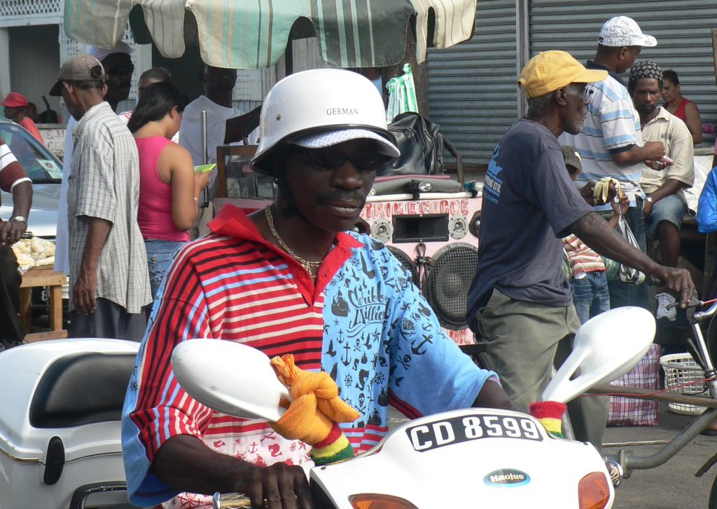 Scooter rider street scene Georgetown Guyana