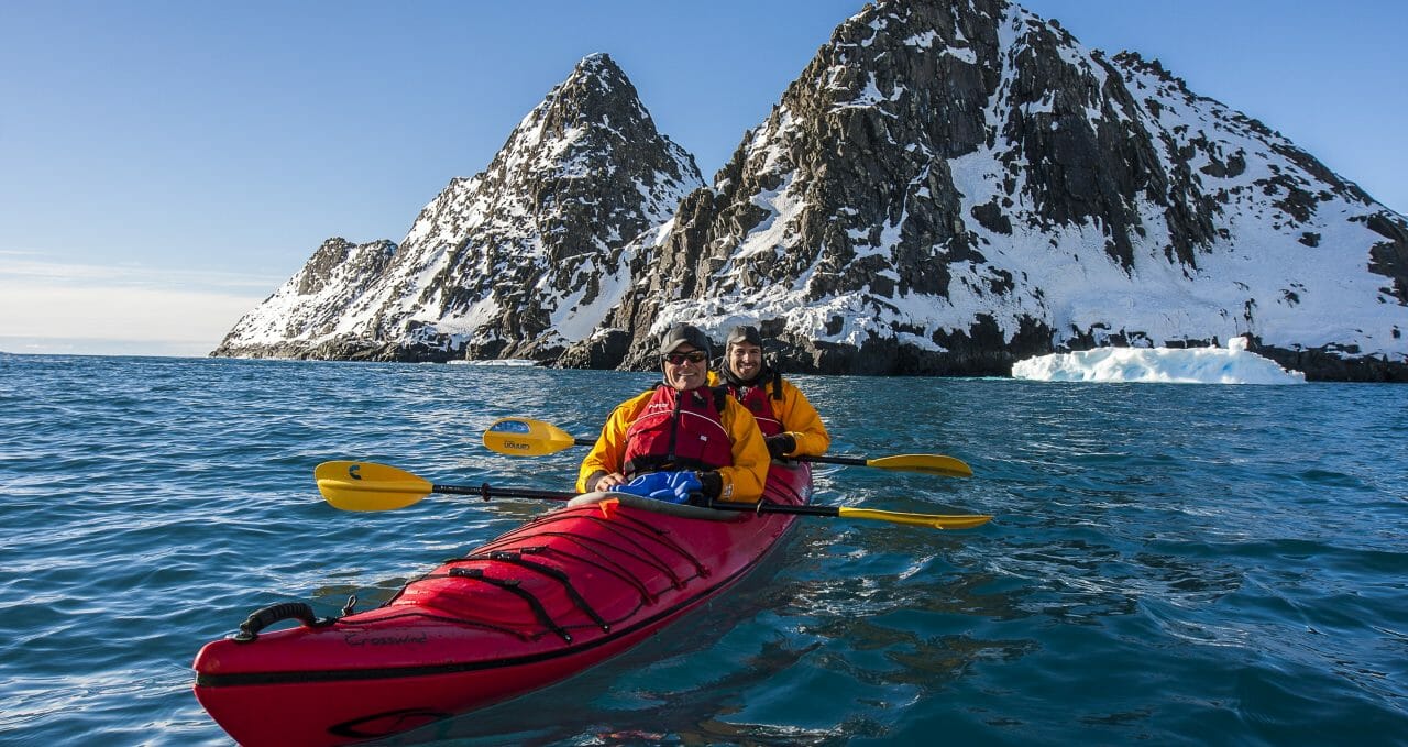 Kayakers kayak in sea on Antarctica XXI.