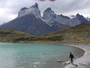 boy beside lake mountains behind