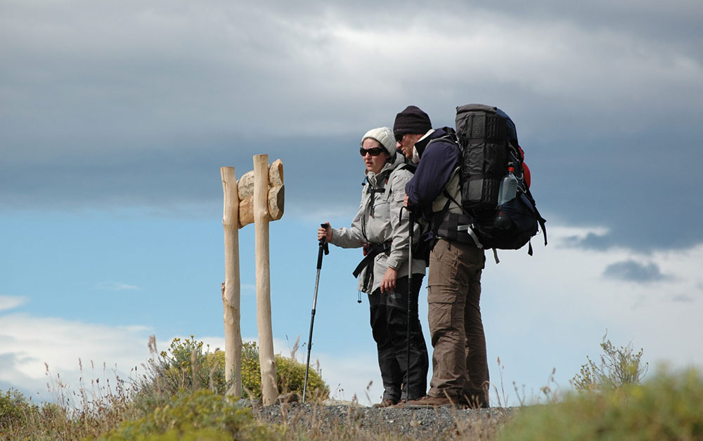 trekkers look at sign torres del paine patagonia chile