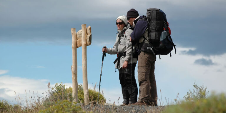 trekkers look at sign torres del paine patagonia chile